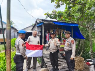 Polsek Kuindra Bagikan dan Pasang Bendera Merah Putih di Rumah Warga Kelurahan Sapat